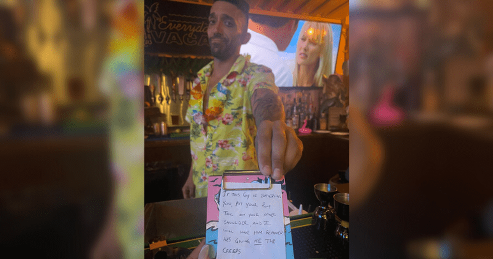 A bartender hands over a note.