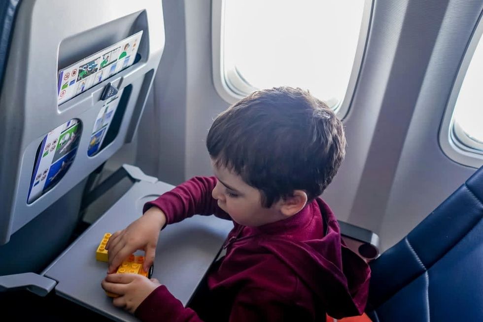 A child at a window seat on a plane.