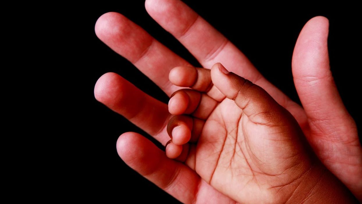 A child's hand in an adults hand.
