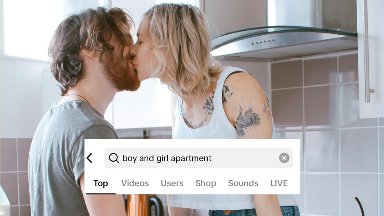 A man and woman kissing in the kitchen
