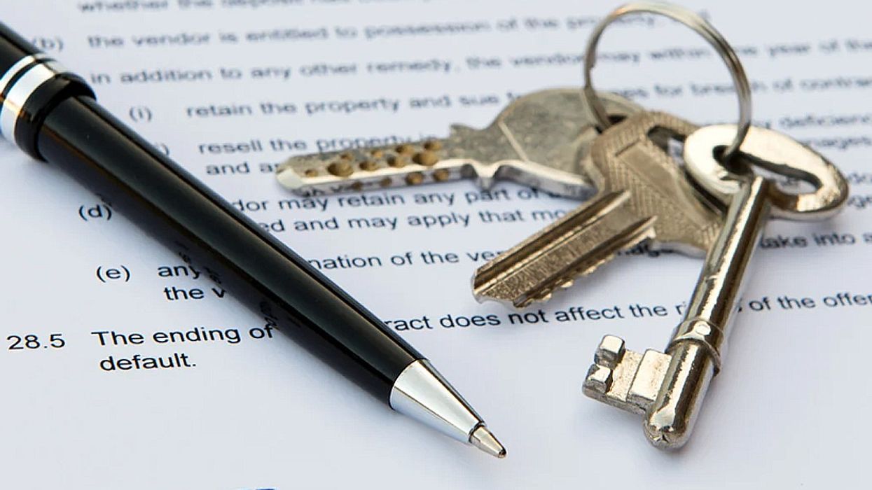 A pen and keys on the deed to a house.