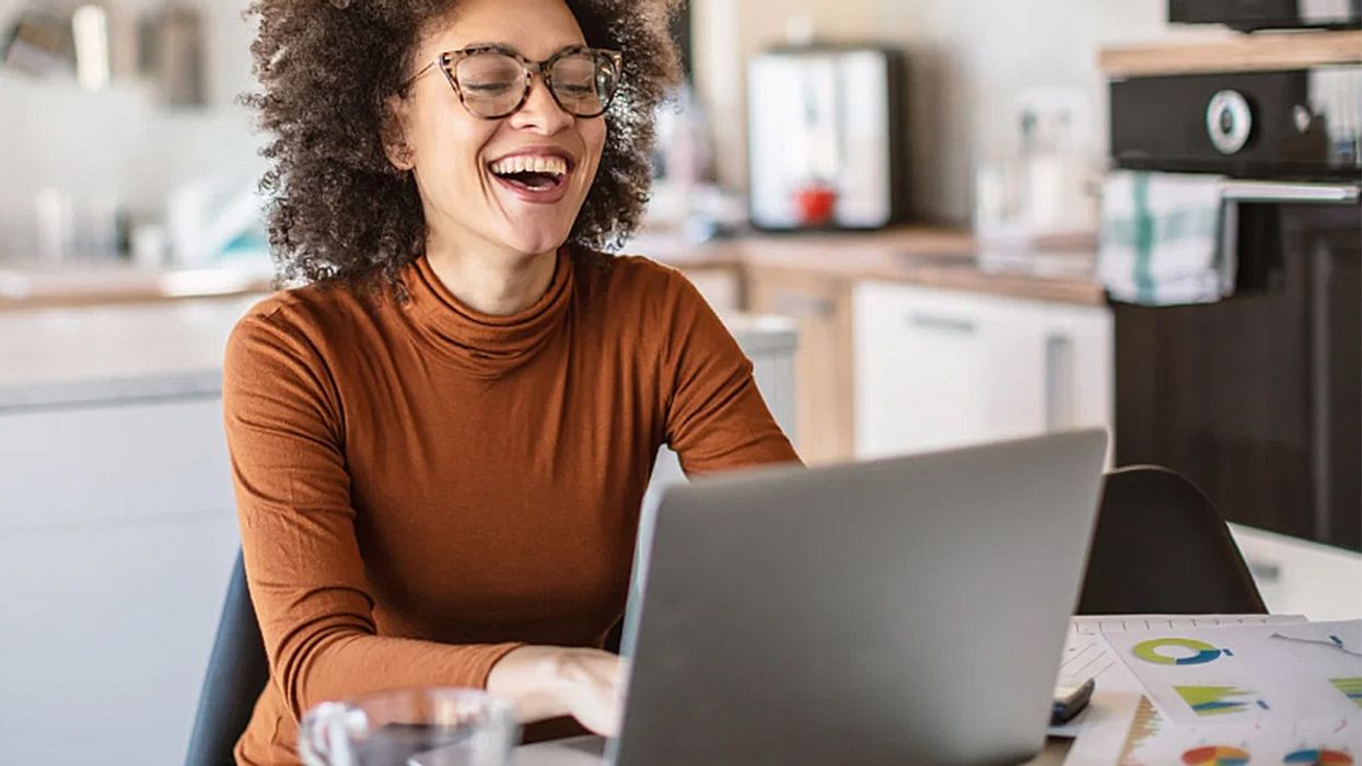 A woman having a laugh at her computer.