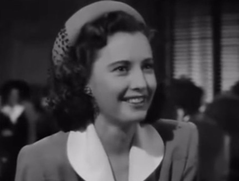 Black-and-white image of an actress laughing on set.