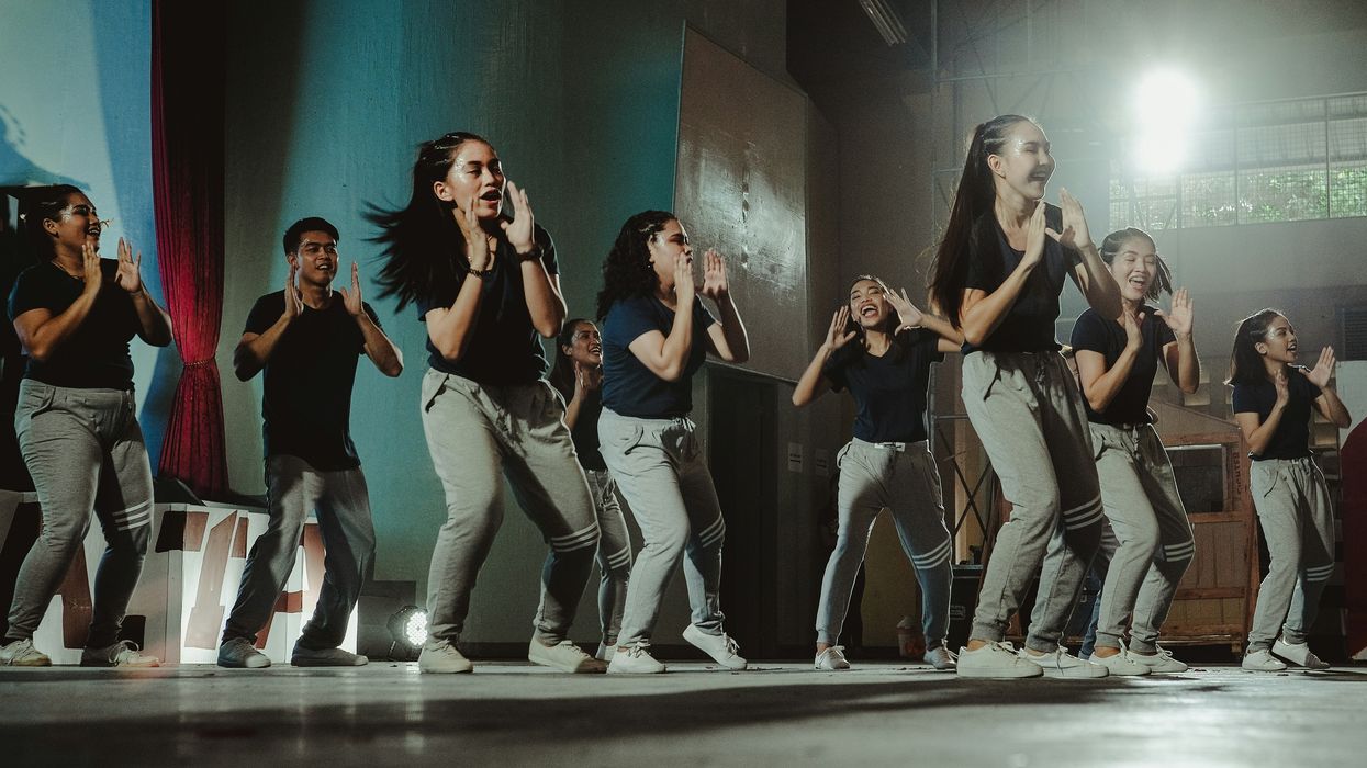 group of kids dancing in black shirts and jeans