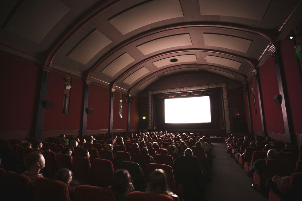 Group of people in a narrow theater, staring at the screen