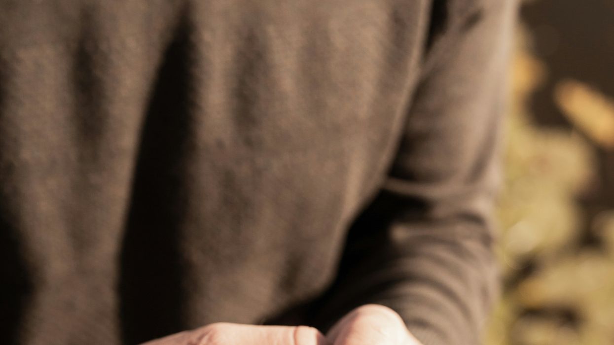 man holds woman's hand with engagement ring on her finger