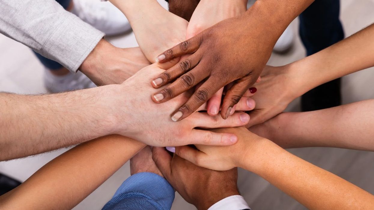 Many hands stacked atop each other.