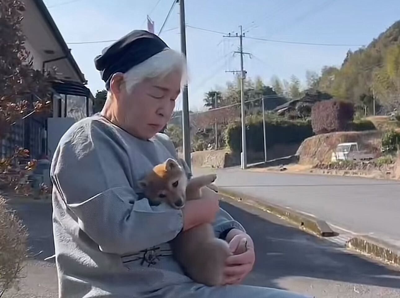 Older woman cradling a small puppy