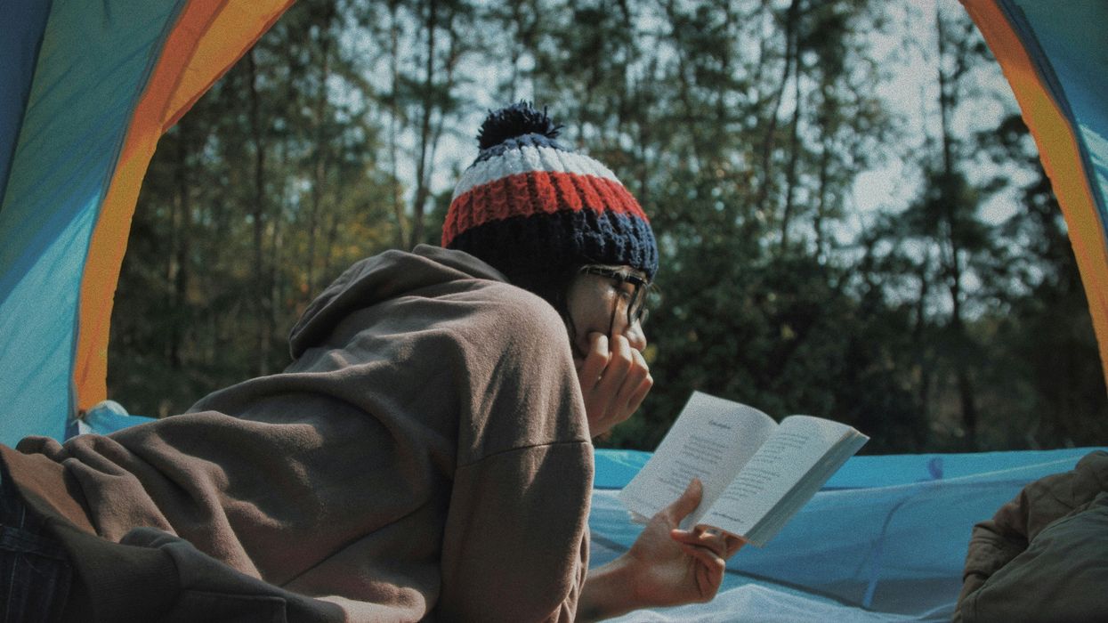 woman reading book in tent