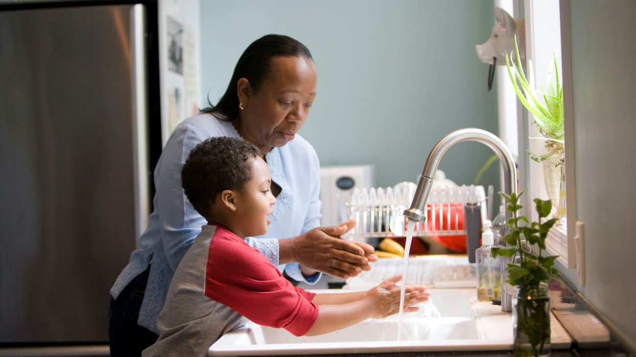 Woman standing at the sink with a young boy